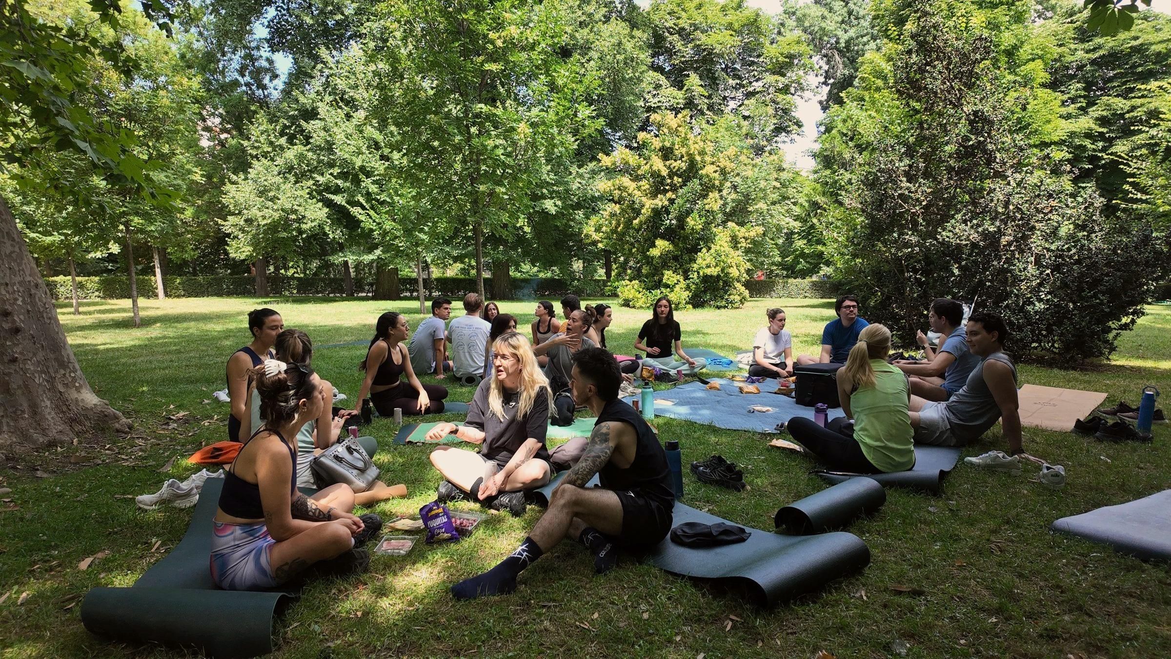 Un grupo de migrantes hispanos reunido en un parque de Madrid, conversando en corro